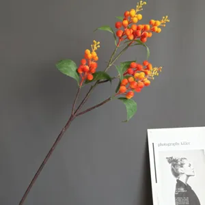 Artificial orange berries branch detail, vibrant foam fruit decor for home interior and wedding.