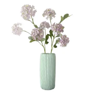 Flores artificiales de hortensia con florero estriado para una elegante decoración.