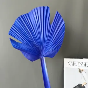 Gedetailleerd uitzicht op blauw kunstpalmblad, modern interieurdecor en bloemstuk accessoire.