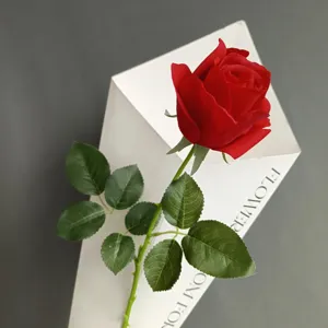 Rosa roja artificial de tallo único con papel de envolver blanco para decoración de bodas en casa.