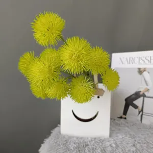 Artificial spiky ball flower detail shot, vibrant yellow dandelion decor in white smiley vase.