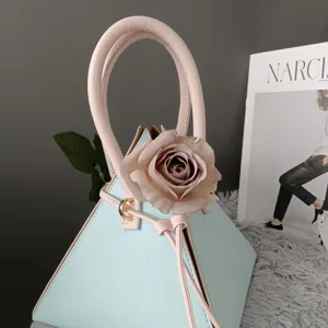 Chic bolso de mano triangular en azul pastel y rosa con elegante rosa decorativa mujer.