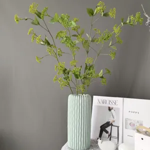 Künstlicher grüner Fruchtzweig in Keramikvase, elegante Heimtextilien Blumenarrangement.