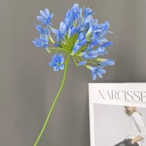 Dettaglio di fiore artificiale di agapanto blu a stelo singolo per decorazione domestica.