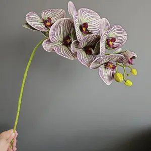 Vista dettagliata del ramo di orchidea phalaenopsis artificiale con motivi e boccioli.