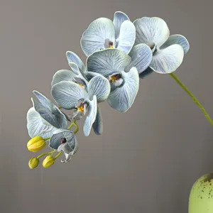 Primo piano dettagliato di ramo di orchidea phalaenopsis blu artificiale con boccioli eleganti.