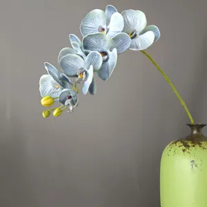 Primo piano di orchidea phalaenopsis artificiale in silicone 3D blu grigio con vaso verde.