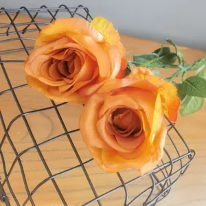 Vue de détail de roses artificielles orange, idéale pour la décoration intérieure et la photo.