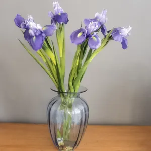 Détail de fleurs d'iris artificielles en PU avec des pétales violets réalistes dans vase.
