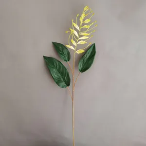 Detailaufnahme des künstlichen Blumenzweigs mit gelben Blüten und grünen Blättern zuhause.