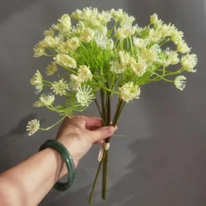 Detail shot of artificial lace flower bouquet held in hand, showing realistic texture and form.