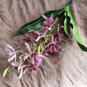 Close-up detail of artificial striped orchid flower, simulation floral decor for home.