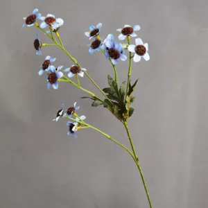 Close-up detail shot of artificial blue daisy flower branch with fuzzy brown core decor.
