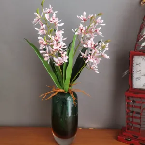 Artificial orchid flower in dark green glass vase for modern home decor arrangement