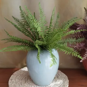 Primo piano di pianta di felce verde artificiale in vaso di ceramica, dettaglio casa.