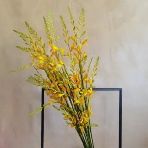 Close-up detail of artificial yellow crocosmia flower branch for home decoration.