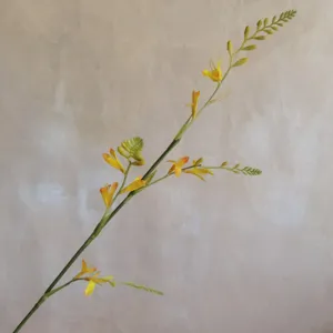 Artificial flower branch detail, close up of yellow blooms and buds for home decor.