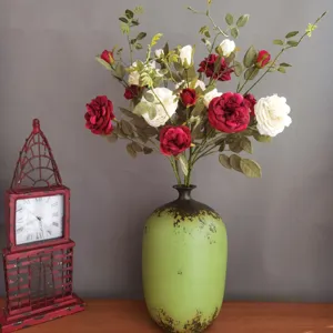 Künstliche Rosen Blumenarrangement mit vintage grüner Keramikvase für Heimdekoration.