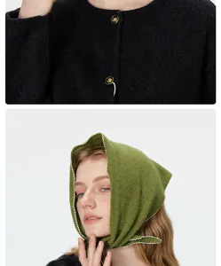 Détail de foulard en tricot avec texture douce, boutons métalliques et bord festonné.