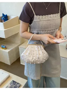 Elegante perlenbesetzte Muschel-Clutch mit goldener Kette und Kussverschluss-Detail.