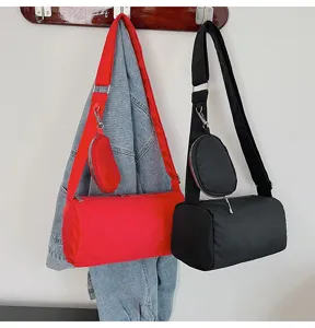 Detailed view of the stylish nylon cylinder crossbody bag featuring a handy detachable pouch strap.