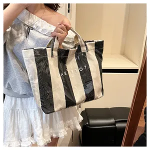Detailed view of the striped coated canvas tote bag with lettering, perfect for daily use.
