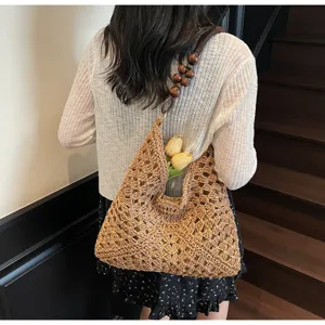 Handmade crochet straw shoulder bag with wooden bead handle, elegant French hollow-out detail.