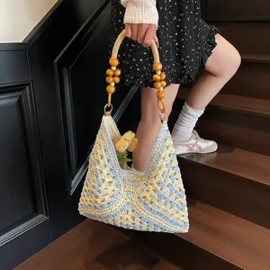 Handmade crochet straw shoulder bag with wooden bead handle for beach vacation style