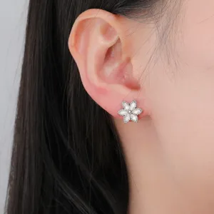 Close-up detail shot of the mini six-petal flower stud earring worn on ear, elegant and refined style.