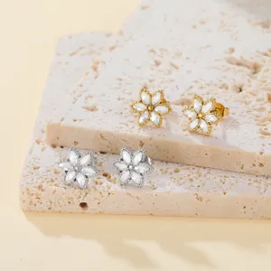 Close-up detail of six-petal flower stud earrings with sparkling zirconia crystals.