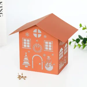 Close-up detail of orange laser cut paper Christmas house lamp shade with hollow festive patterns.
