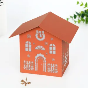 Christmas paper hollow night light house decoration, cute orange DIY holiday gift display.