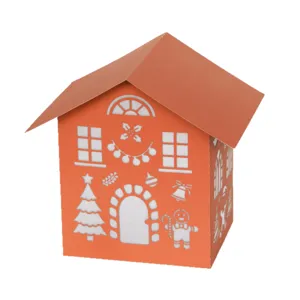 Orange paper Christmas house lantern with laser cut festive holiday patterns for home decor.