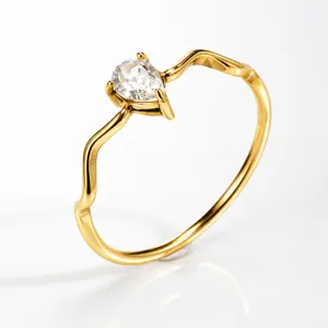 Minimalist gold wavy stainless steel ring featuring a sparkling pear-shaped cubic zirconia.