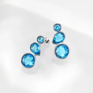 Detailed close-up of multi-stone blue crystal drop earrings with fine silver setting.