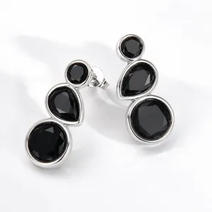 Detailed close-up of geometric silver-tone earrings featuring elegant black stone drop accents.