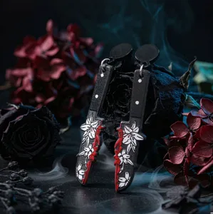 Nahaufnahme Detail der gotischen Halloween Acryl Messer Ohrringe mit Blumen und Blut Design.