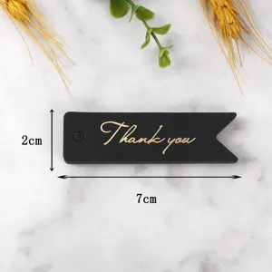 Detail view of black swallowtail gift tag with gold foil thank you text, 2x7cm size.