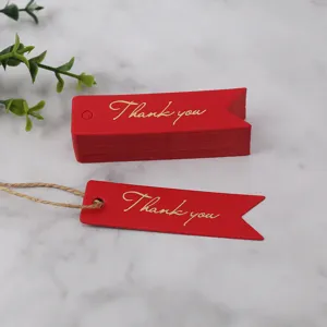 Red swallowtail paper gift tags with gold foil Thank you text and hemp twine, close-up detail.