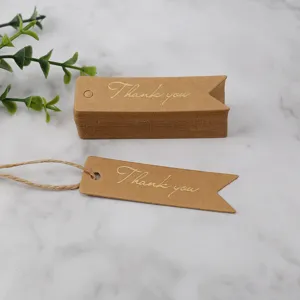 Kraft paper thank you tags close-up detail shot with twine and gold foil lettering.