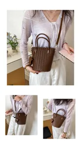 Borsa a secchiello in pelle intrecciata marrone con manico e tracolla, elegante e versatile.