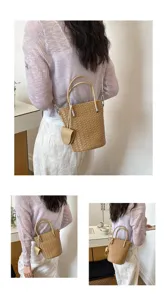 Elegante borsa a secchiello in pelle intrecciata da donna con manico e tracolla per uso quotidiano.