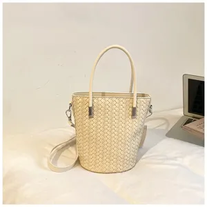 Vista dettagliata della borsa a secchiello intrecciata con design elegante e tracolla.