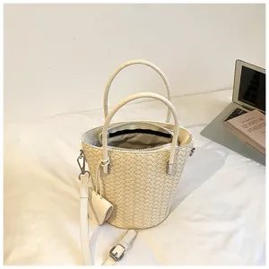 Borsa a secchiello intrecciata bianca dettaglio con manici robusti e tracolla comoda.