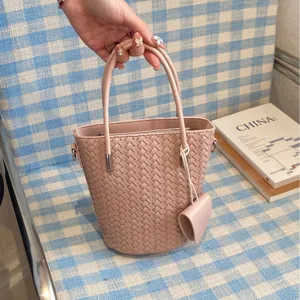 Elegante borsa a secchiello in pelle intrecciata rosa da donna, borsa alla moda casual.