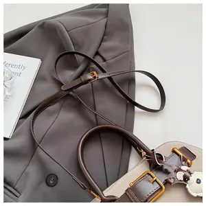Nahaufnahme der strukturierten Wildleder-Handtasche mit feinem Schnallenriemen und Patchwork.