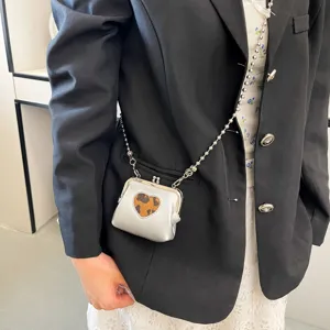 Detailed view of the mini silver kiss lock purse showcasing stylish bead chain and leopard heart.
