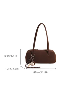 Brown suede baguette shoulder bag with mini baseball charm, stylish underarm purse.
