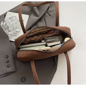 Interior detail of the soft suede baguette bag, featuring spacious capacity and handy compartments.
