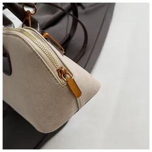 Nahaufnahme der schicken Retro Wildleder Patchwork Handtasche mit Metallreißverschluss.